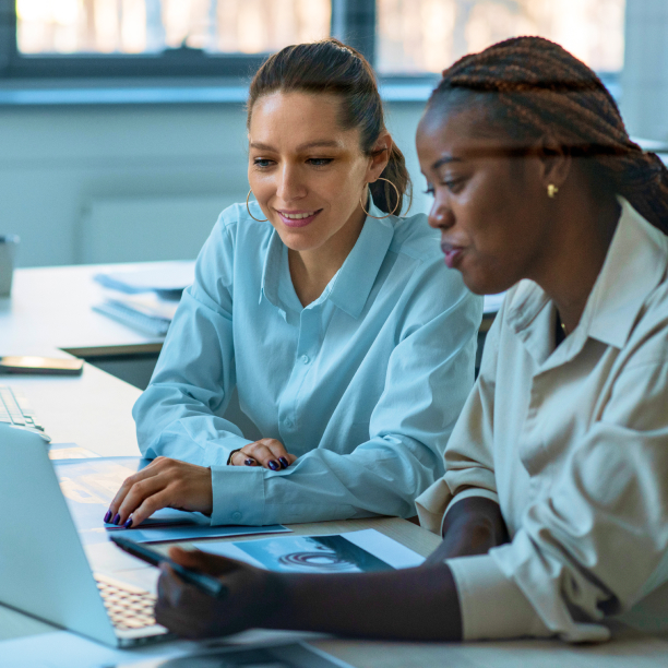 Duas mulheres usando o computador e analisando dados